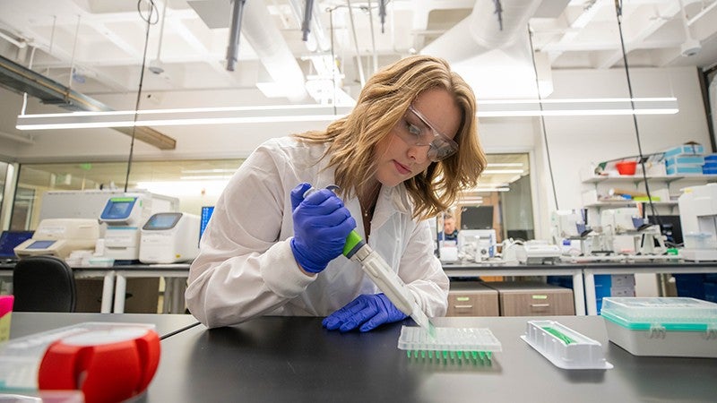 female student pipetting in a lab